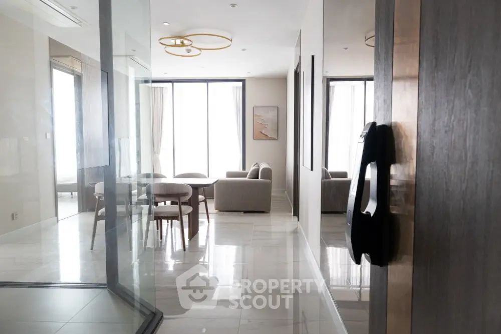 Modern living room with elegant furniture and large windows, offering a bright and inviting atmosphere.