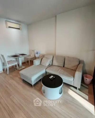 Cozy living room with modern furniture and air conditioning, perfect for relaxation.