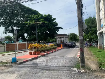 Charming gated entrance with lush greenery and secure access in a serene neighborhood.