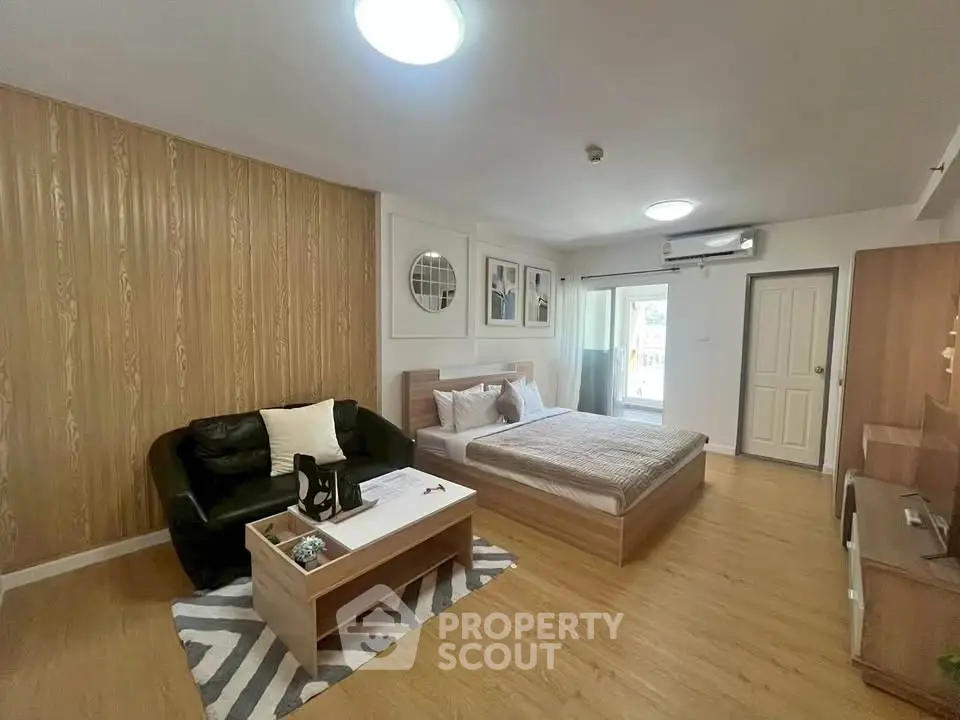 Spacious modern bedroom with stylish decor and cozy seating area, perfect for relaxation and comfort.