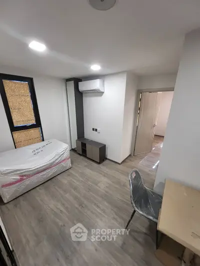 Modern bedroom with sleek flooring and air conditioning in a stylish apartment.