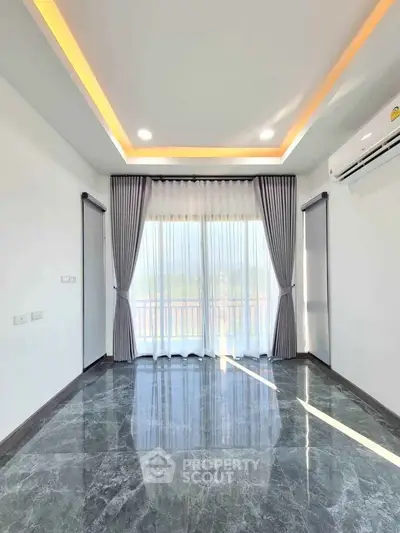 Spacious modern living room with marble flooring and large windows for natural light.