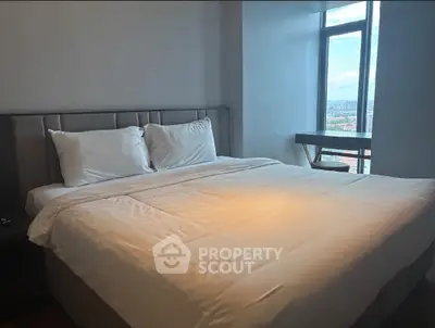 Spacious bedroom with large window offering city views, featuring a comfortable bed and modern decor.