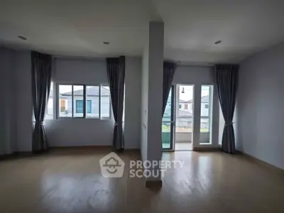 Spacious empty room with large windows and balcony access, perfect for customization.