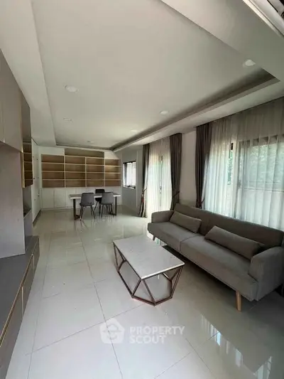 Spacious modern living room with sleek furniture and large windows for natural light.