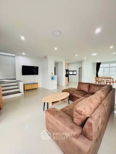 Spacious modern living room with plush brown sofa and sleek TV setup