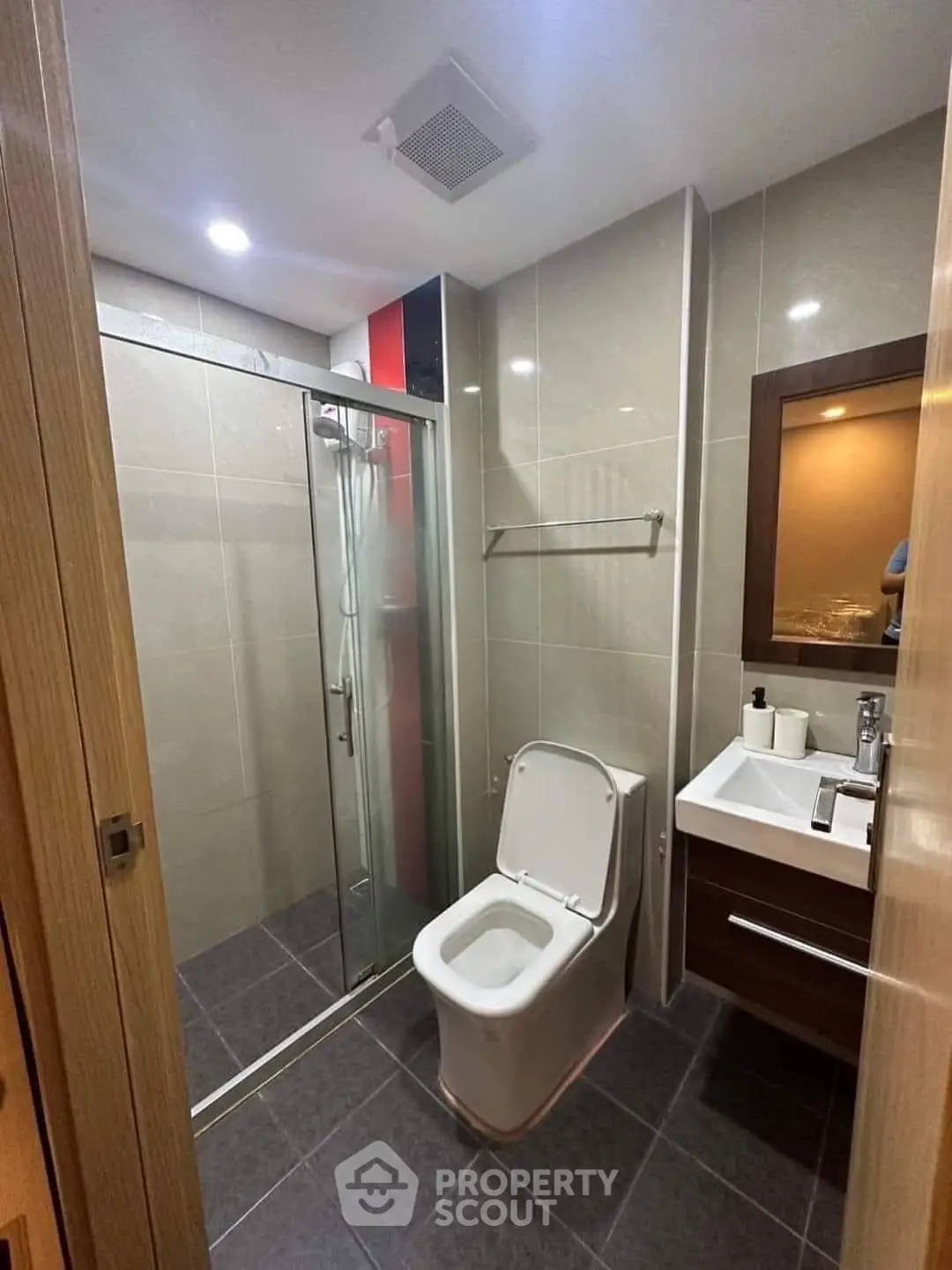Modern bathroom with sleek shower and stylish vanity in contemporary apartment.