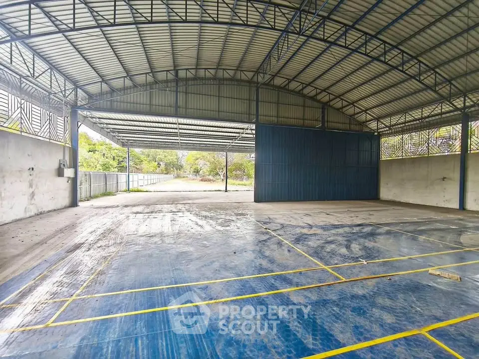 Spacious industrial warehouse with high ceilings and ample natural light.