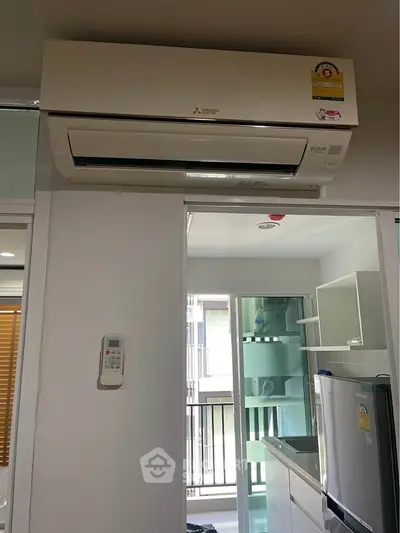 Modern kitchen with air conditioning and sleek appliances in a bright apartment.