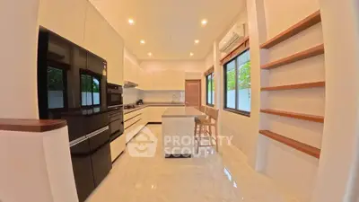 Spacious modern kitchen with sleek black appliances and open layout, perfect for culinary enthusiasts.