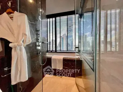 Luxurious bathroom with city view, featuring a glass shower and elegant marble finishes.