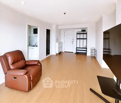 Spacious living room with modern decor and large TV, perfect for relaxation.