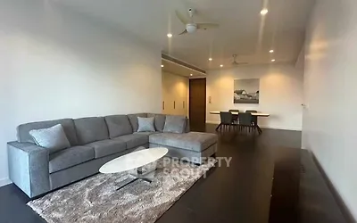 Spacious modern living room with stylish gray sofa and elegant dining area.