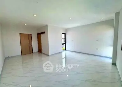 Spacious empty living room with glossy tiled floors and natural light