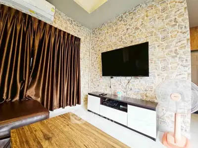 Stylish living room with stone accent wall, modern TV setup, and elegant curtains.