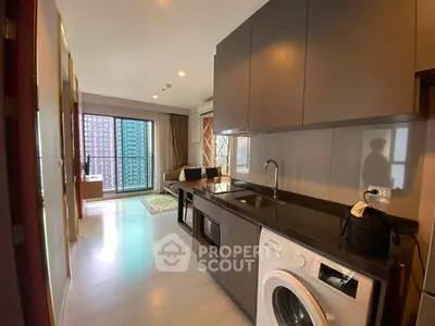 Modern apartment interior with open kitchen and living area, featuring a washing machine and city view.
