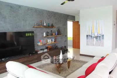 Stylish living room with modern decor, large TV, and cozy seating area, perfect for relaxation and entertainment.
