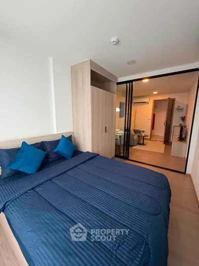 Modern bedroom with blue bedding and sliding glass doors in a stylish apartment.