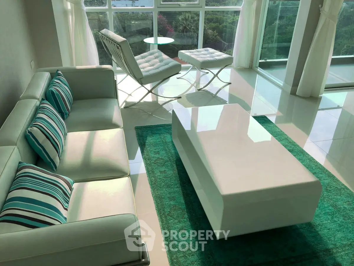 Modern living room with stylish furniture and large windows offering a scenic view.