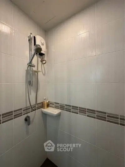 Modern bathroom shower with sleek tile design and wall-mounted showerhead.