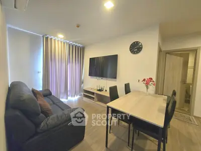 Modern living room with sleek furniture and wall-mounted TV in a cozy apartment setting.