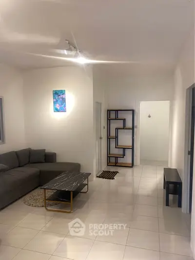 Spacious living room with modern decor and sleek furniture in a contemporary apartment.