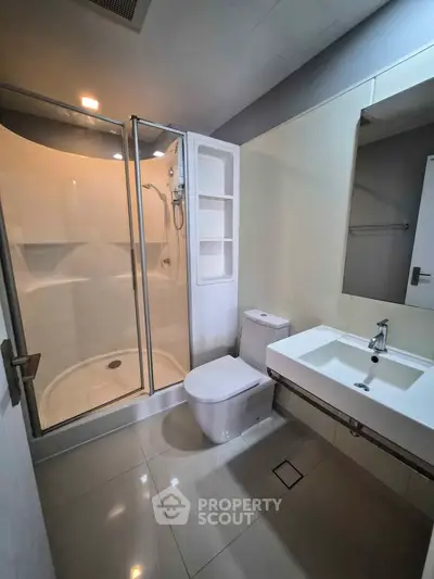 Modern bathroom with sleek shower and contemporary fixtures in a stylish apartment.