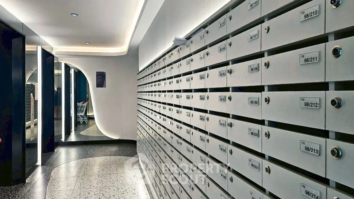 Modern apartment building mailroom with sleek design and numerous mailboxes.
