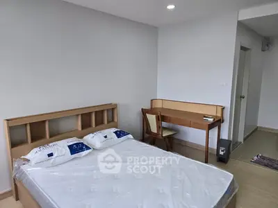 Spacious bedroom with modern furniture and natural light, perfect for comfortable living.