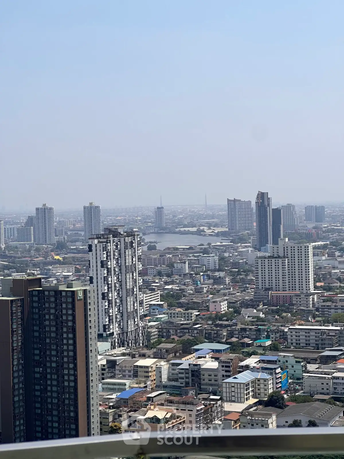 Stunning cityscape view from a high-rise balcony showcasing urban skyline and distant horizon.