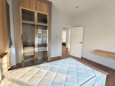 Spacious bedroom with modern wooden wardrobe and natural light