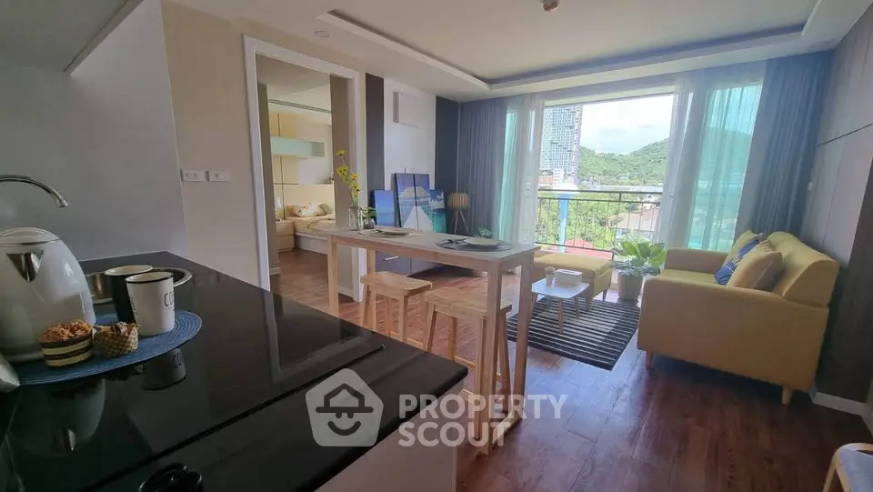 Modern open-plan living room with kitchen and balcony view in a stylish apartment