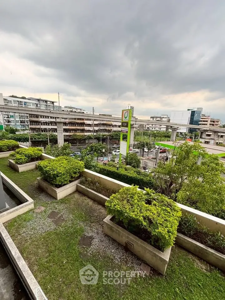 Stunning urban view from a lush green balcony overlooking cityscape and modern infrastructure.