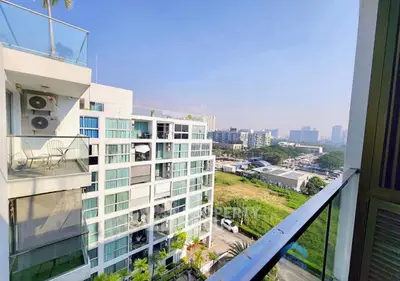 Stunning cityscape view from modern apartment balcony with glass railing.