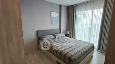 Modern bedroom with large window and stylish decor in a contemporary apartment.