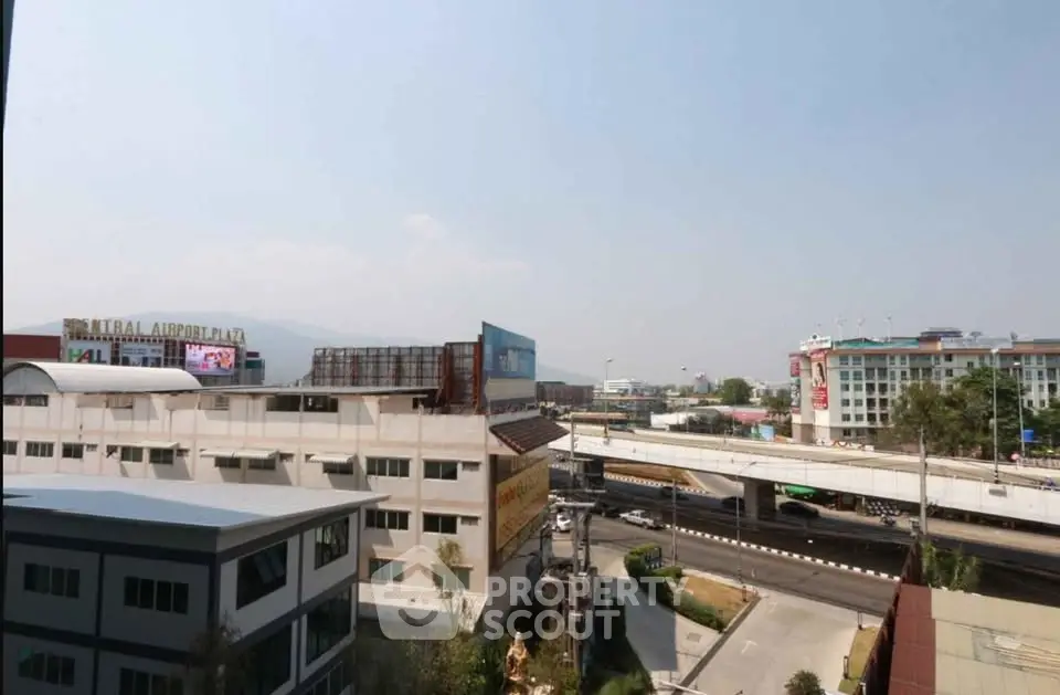Panoramic city view from high-rise building overlooking roads and urban landscape.