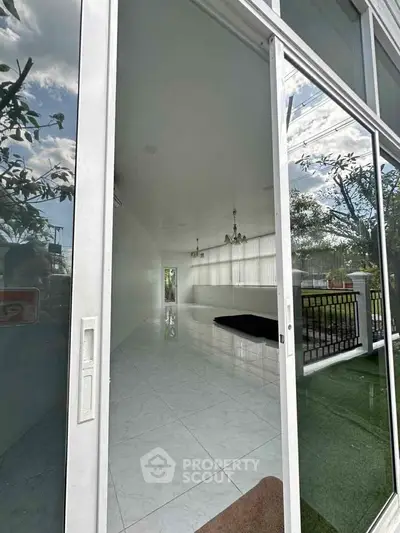 Spacious modern interior with large glass windows and sleek white flooring, offering a bright and airy ambiance.