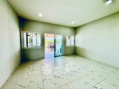 Spacious empty room with tiled floor and large windows leading to a balcony with scenic views.