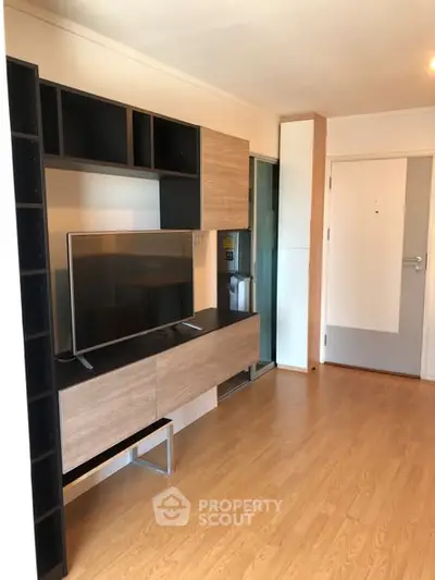 Modern living room with sleek wooden furniture and mounted TV, perfect for cozy entertainment.