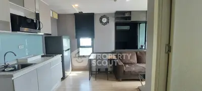 Modern studio apartment with kitchenette and cozy living area, featuring sleek appliances and stylish decor.