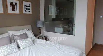 Modern bedroom with stylish decor and large window offering natural light.