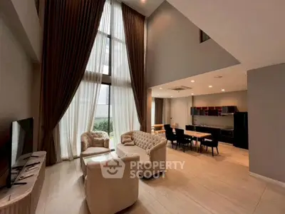 Luxurious high-ceiling living room with elegant furniture and open dining area, perfect for modern living.