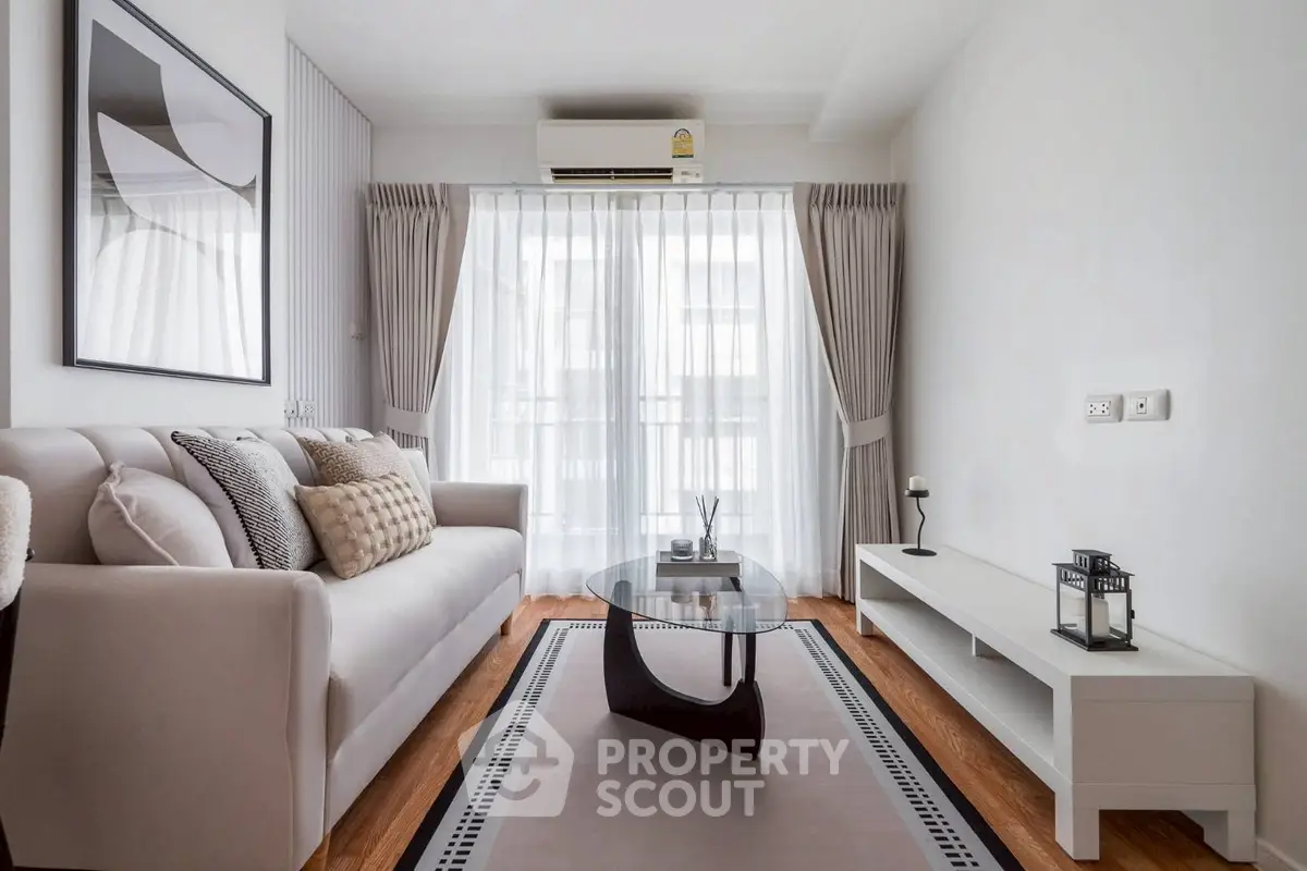 Modern living room with elegant decor, featuring a cozy sofa, stylish coffee table, and large window with curtains.