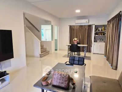 Spacious modern living room with sleek design and elegant decor, featuring a staircase and stylish furniture.