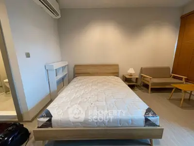 Spacious bedroom with modern furnishings and natural light, perfect for relaxation and comfort.