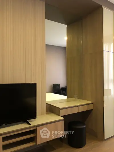 Modern bedroom with sleek wooden furniture and built-in TV unit