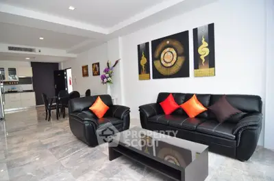 Modern living room with stylish black leather sofas and open kitchen layout