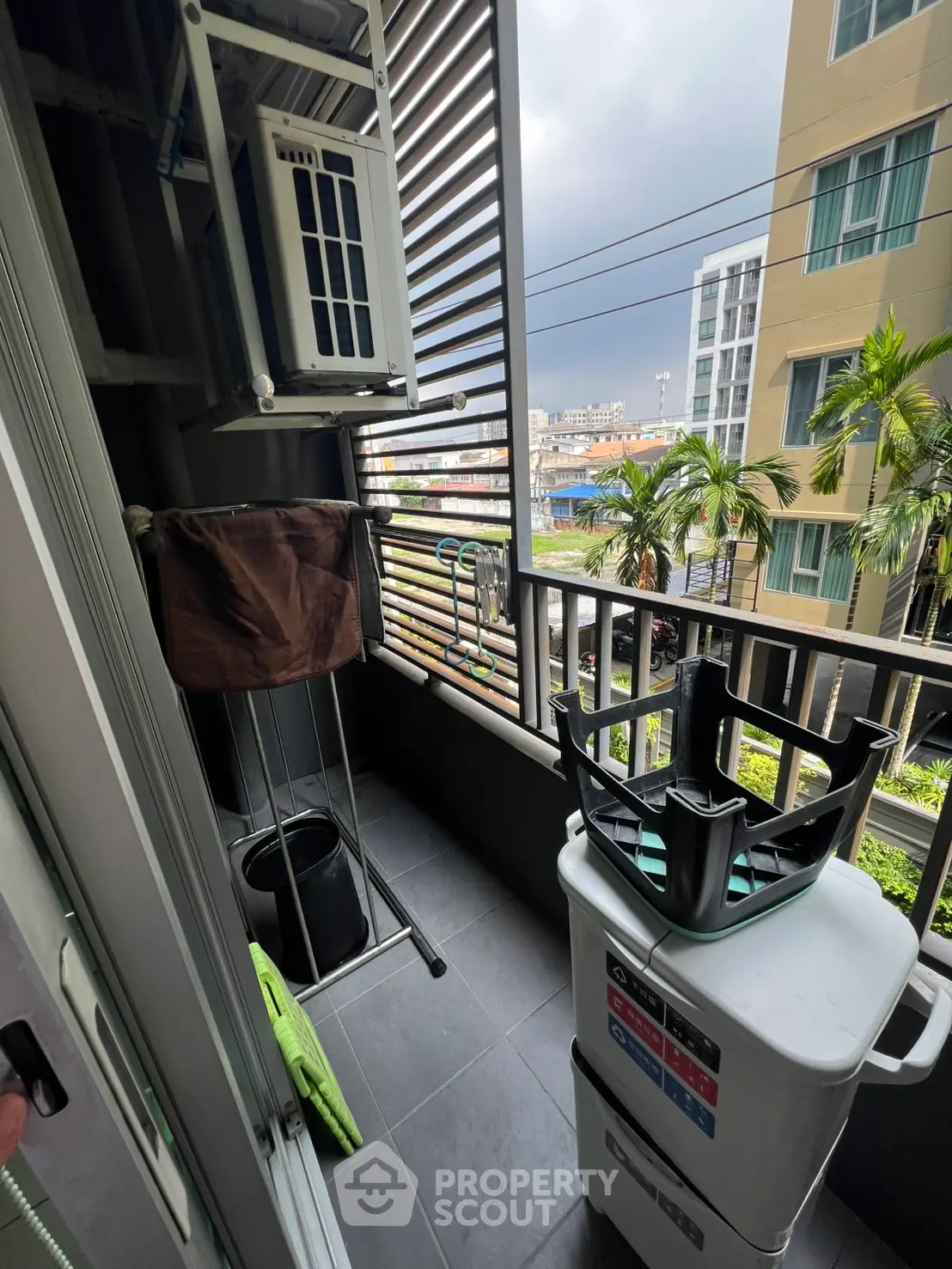 Compact balcony with city view, ideal for laundry and storage, featuring modern railing design.