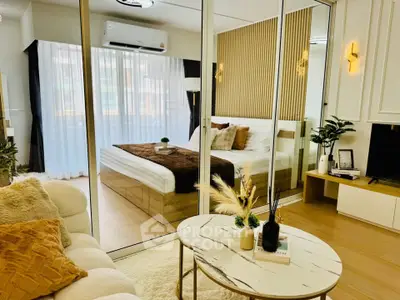 Luxurious modern bedroom with glass partition and cozy living area, featuring elegant decor and natural light.