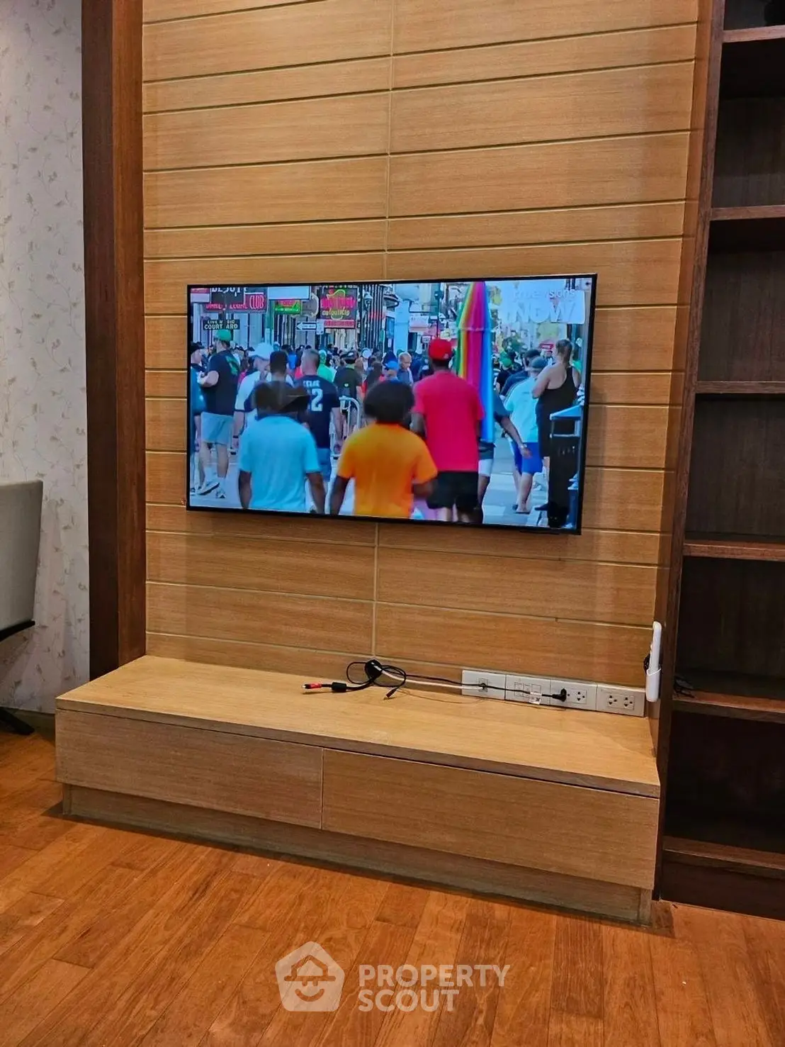 Modern living room with wooden paneling and wall-mounted TV, showcasing stylish interior design.
